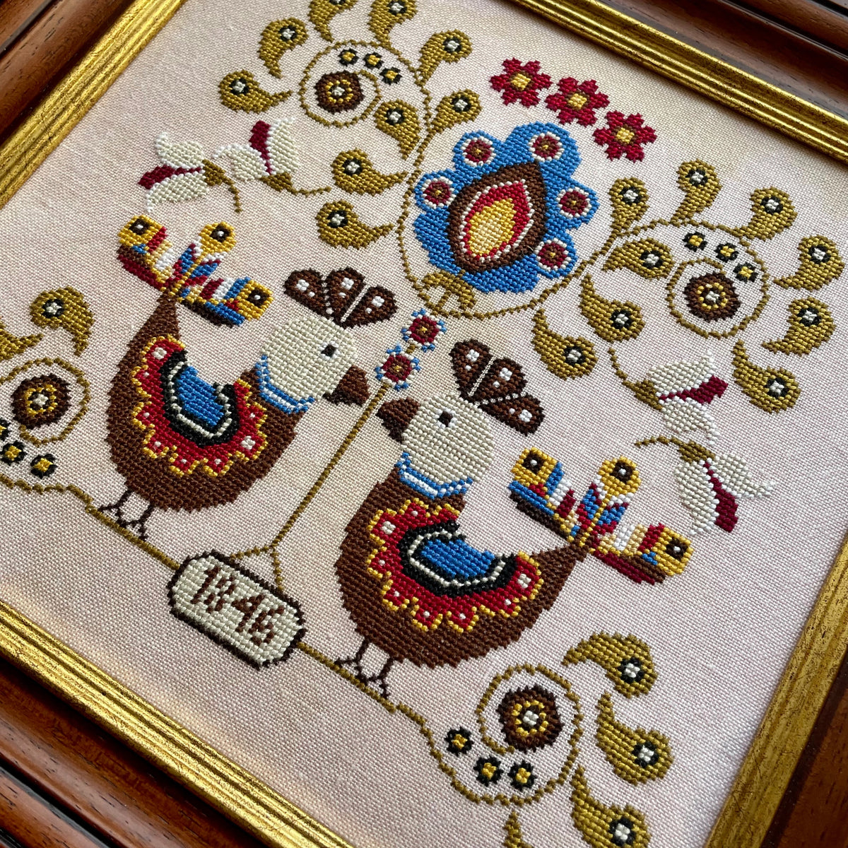 Koguty cross-stitch chart featuring symmetrical folk art birds and floral motifs