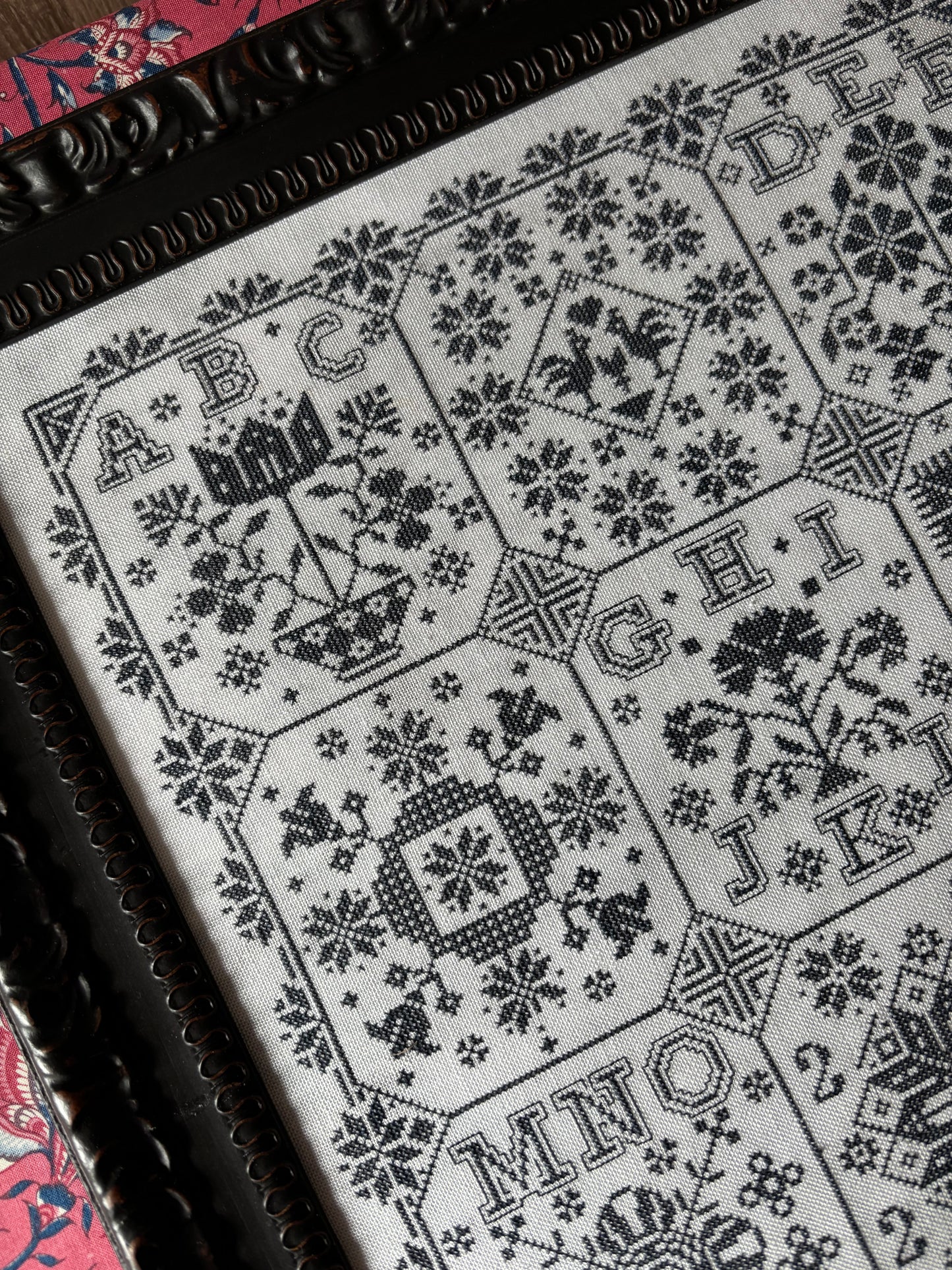 Close-up of a black and white patterned fabric with geometric designs on a wooden surface.