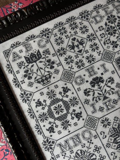 Close-up of a black and white patterned fabric with geometric designs on a wooden surface.