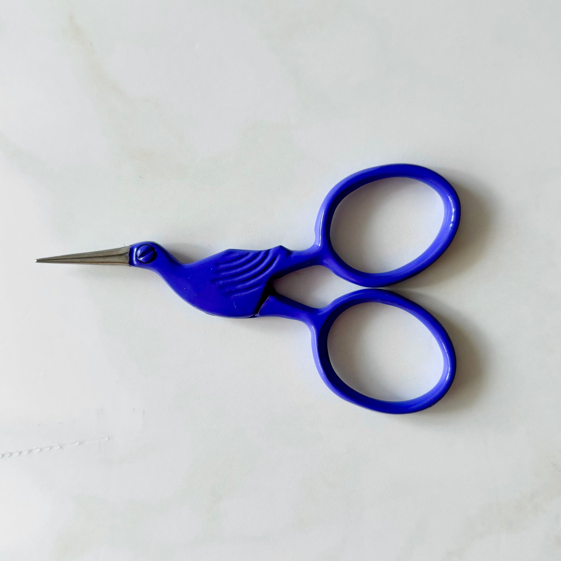 Blue bird-shaped scissors on a white background