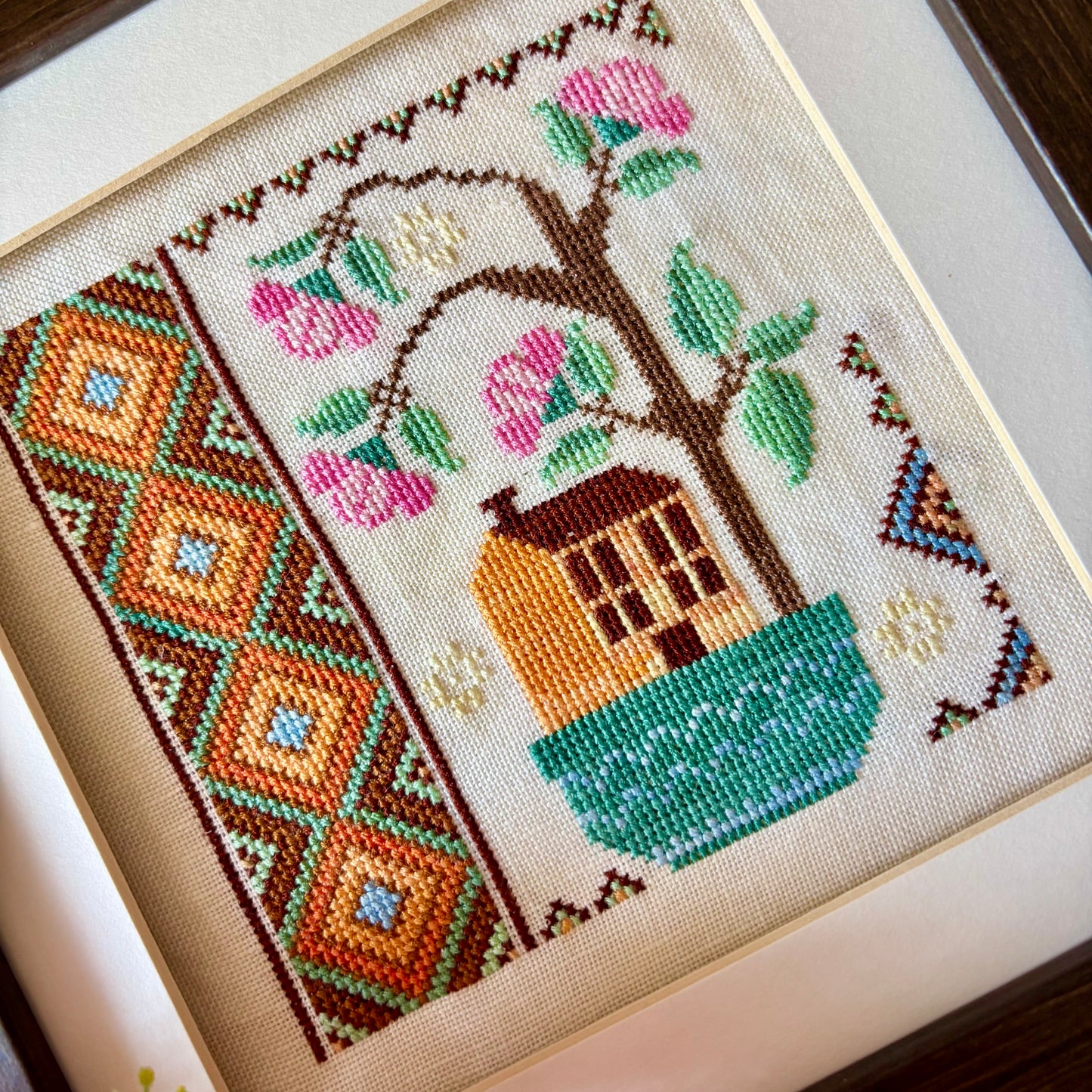 Cross stitch pattern of a whimsical house with a blooming rose tree – Rose Tree House design