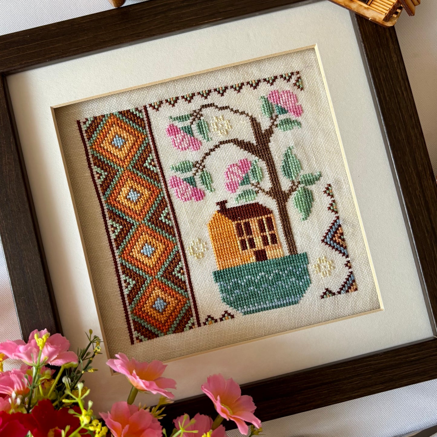 Cross stitch pattern of a whimsical house with a blooming rose tree – Rose Tree House design