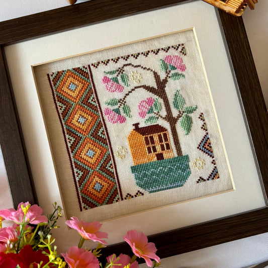 Cross stitch pattern of a whimsical house with a blooming rose tree – Rose Tree House design