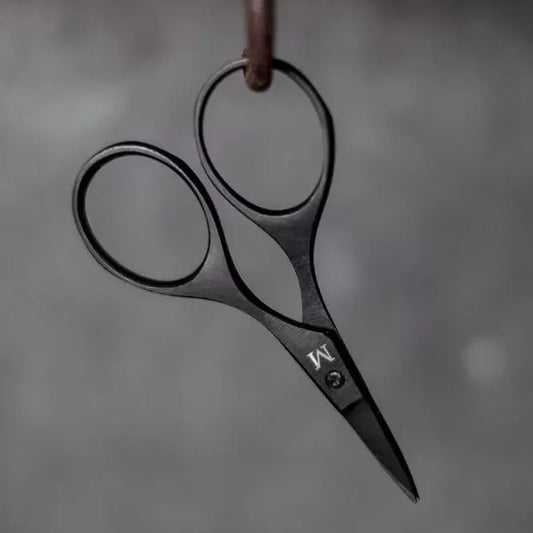 A pair of black metal scissors with a matte finish and a small silver logo, hanging from a brown loop against a dark gray textured background.