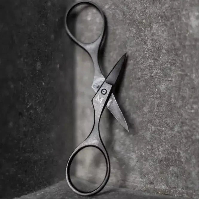 Pair of scissors on a textured surface