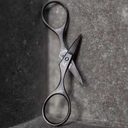Pair of scissors on a textured surface