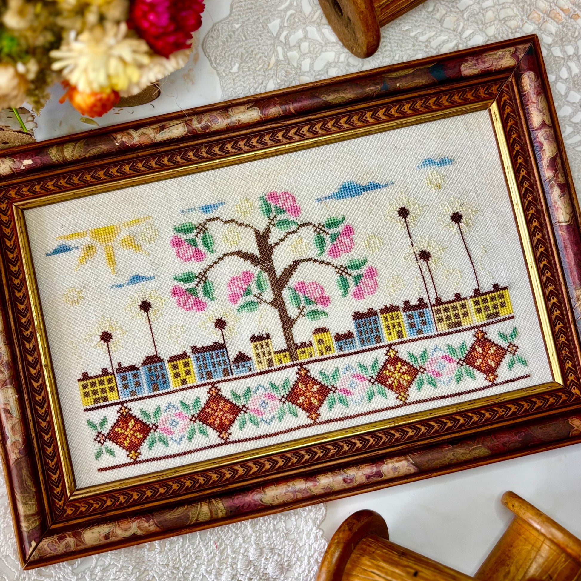 ose Tree Road cross-stitch pattern with floral design in soft pink and green tones