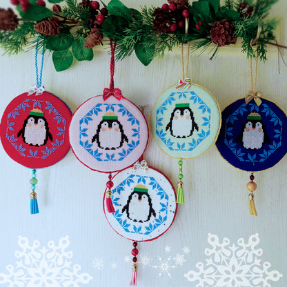 Decorative penguin ornaments with colorful backgrounds on a white background with snowflake decorations.