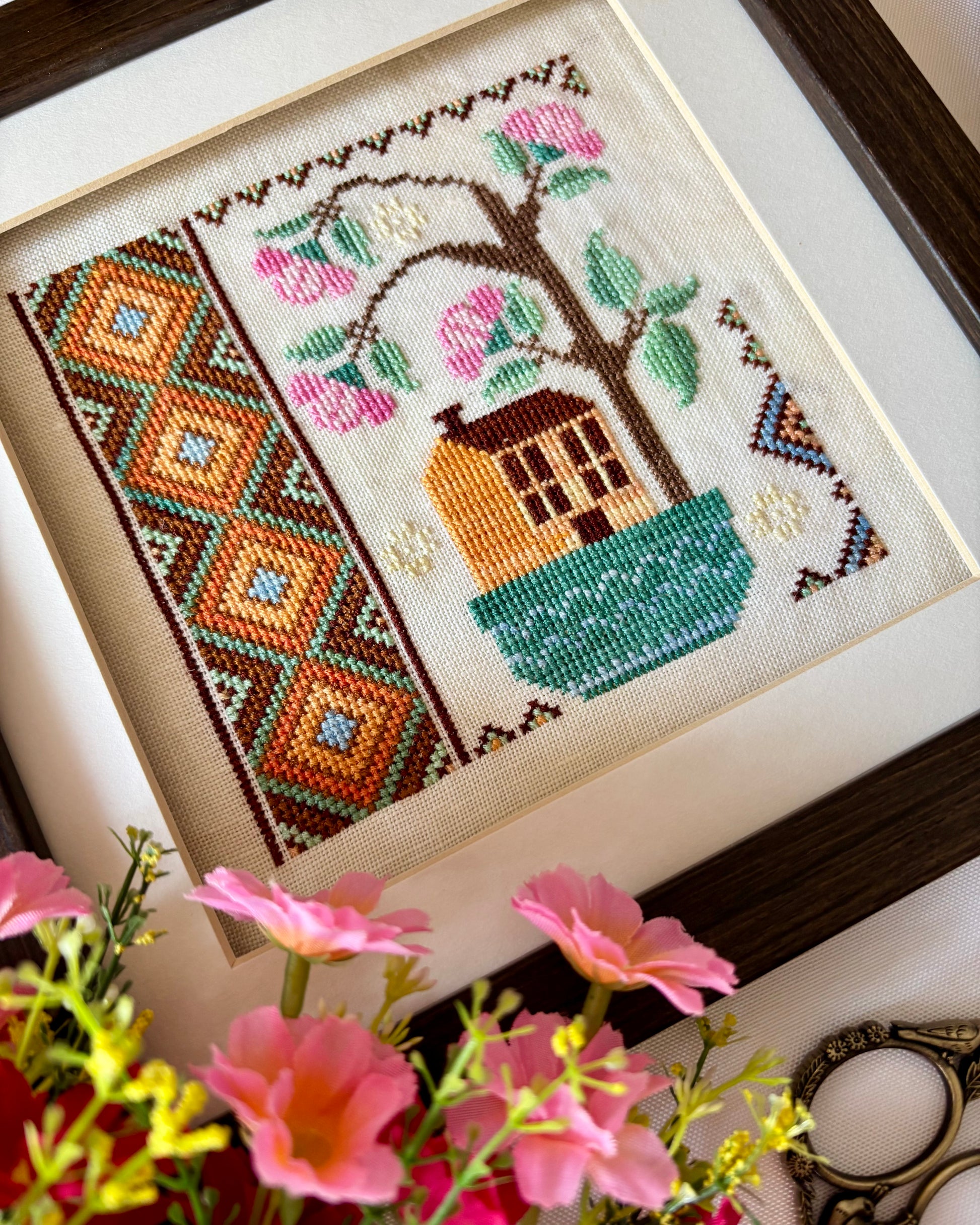Cross stitch pattern of a whimsical house with a blooming rose tree – Rose Tree House design