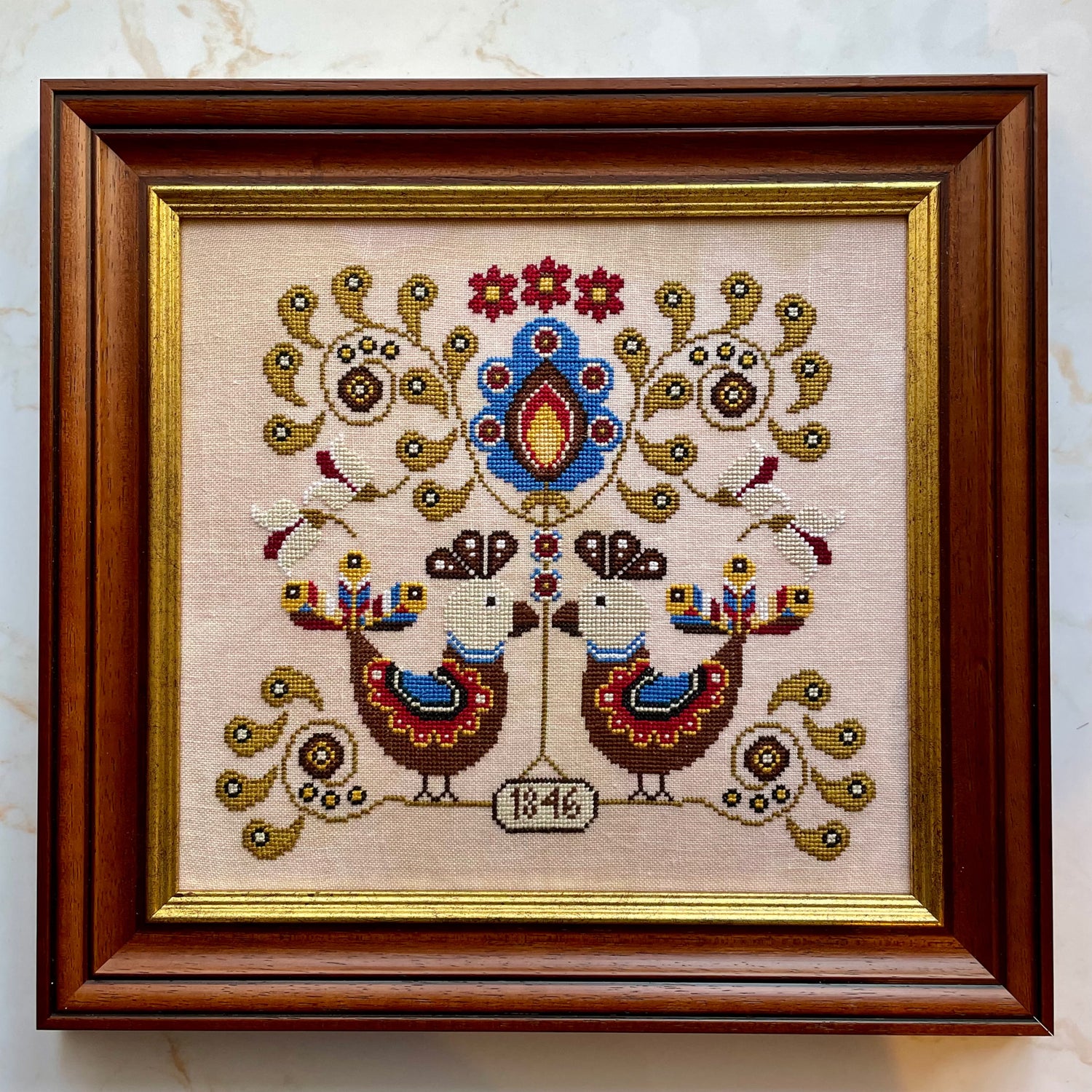 Koguty cross-stitch chart featuring symmetrical folk art birds and floral motifs