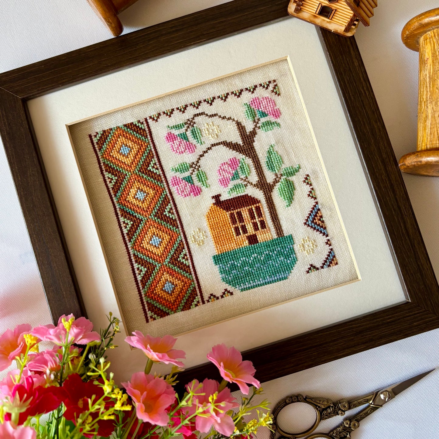 Cross stitch pattern of a whimsical house with a blooming rose tree – Rose Tree House design