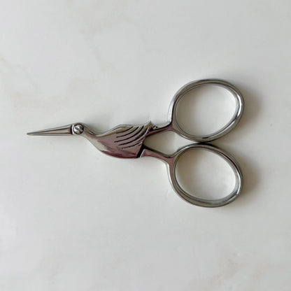 Pair of silver embroidery scissors on a white background