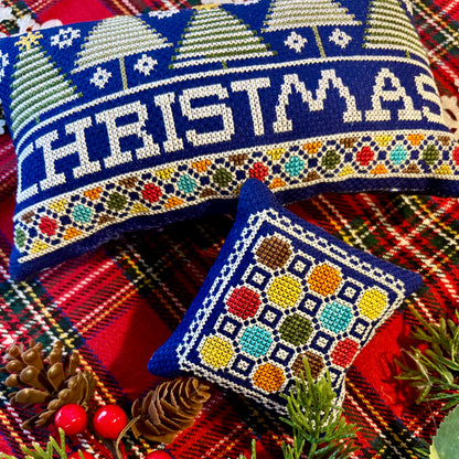 Decorative Christmas pillow with 'Christmas' text on a plaid fabric background.