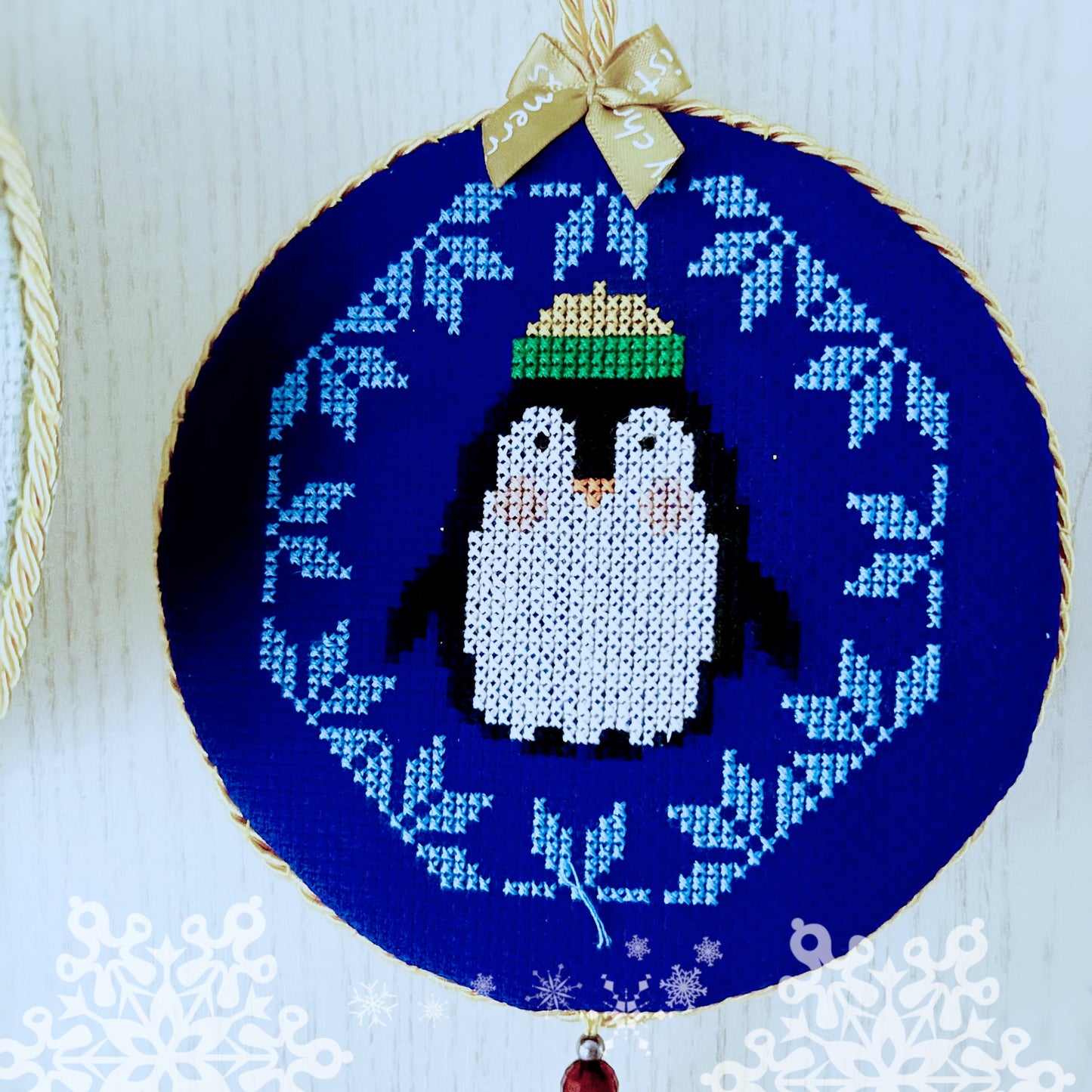 Embroidery hoop with a penguin design on a blue background