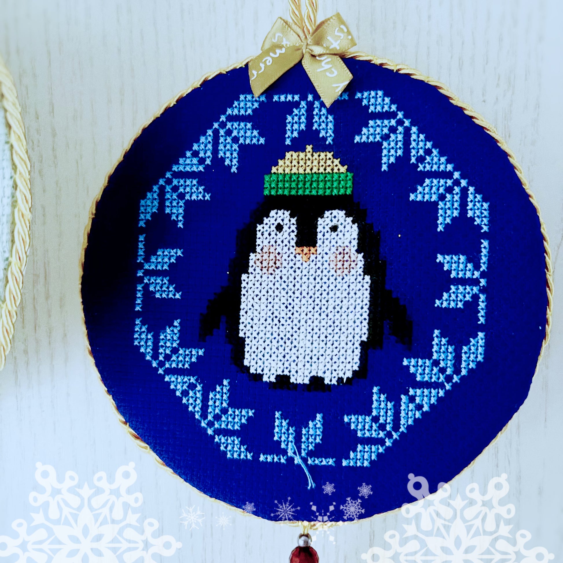 Embroidery hoop with a penguin design on a blue background