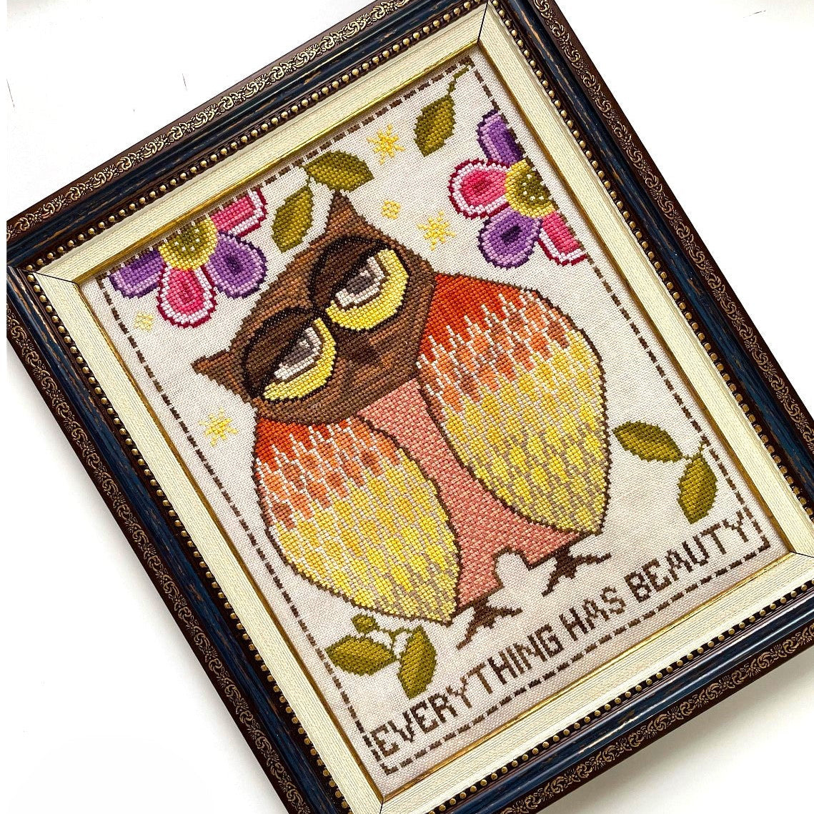 Embroidered picture of an owl with flowers and 'Everything has beauty' text in a decorative frame.