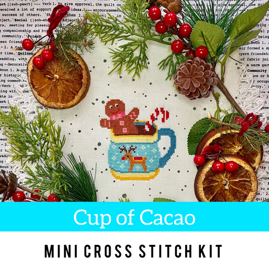 Mini cross stitch kit with a cup of cacao design, surrounded by Christmas elements on a textured background.