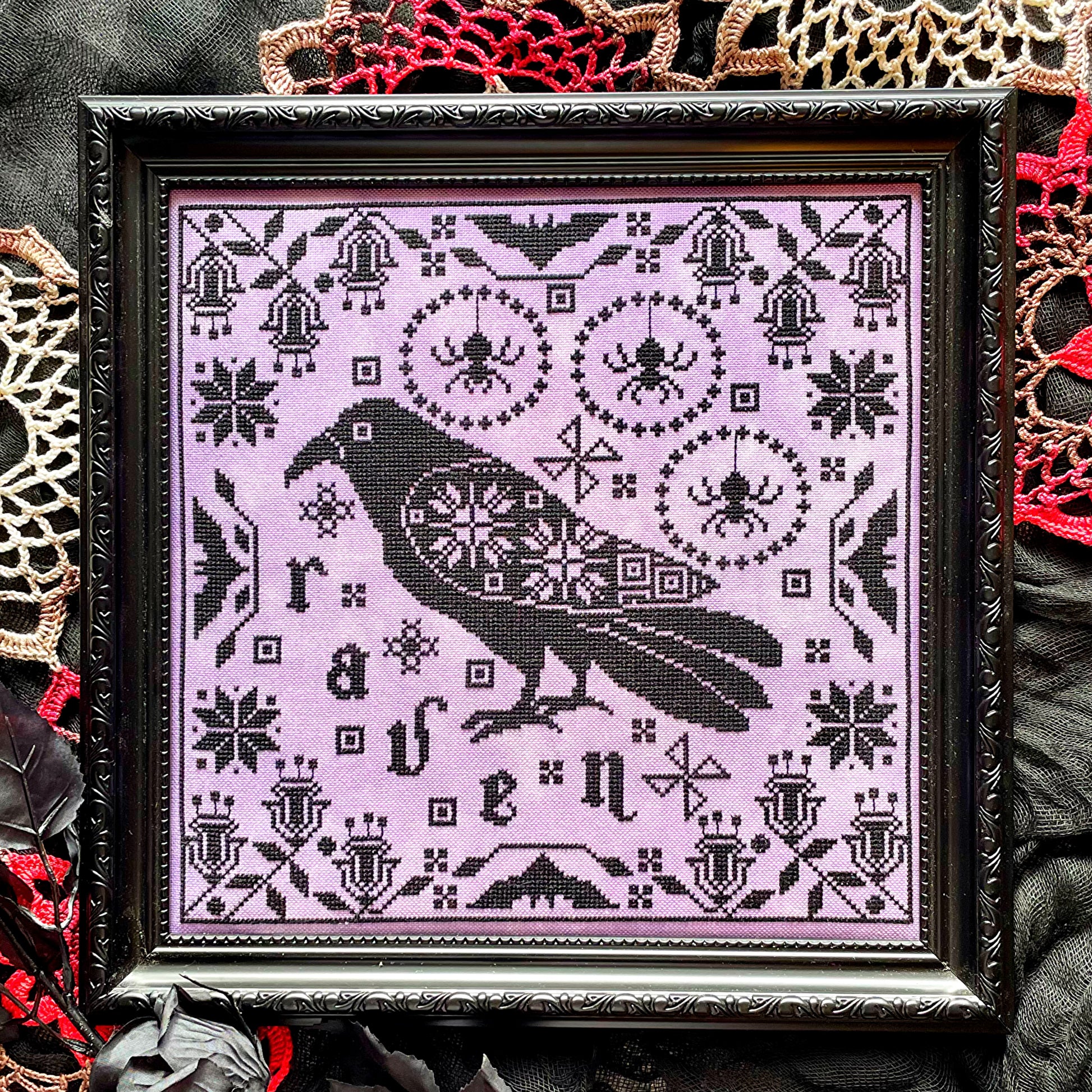 Raven cross-stitch pattern featuring black bird and decorative foliage