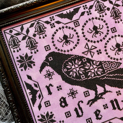 Raven cross-stitch pattern featuring black bird and decorative foliage