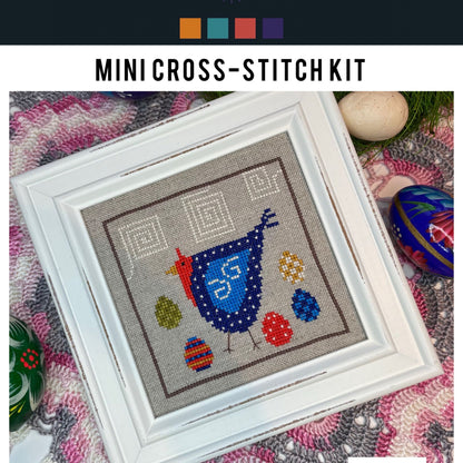 Mini cross-stitch kit with a blue bird design on a textured fabric background