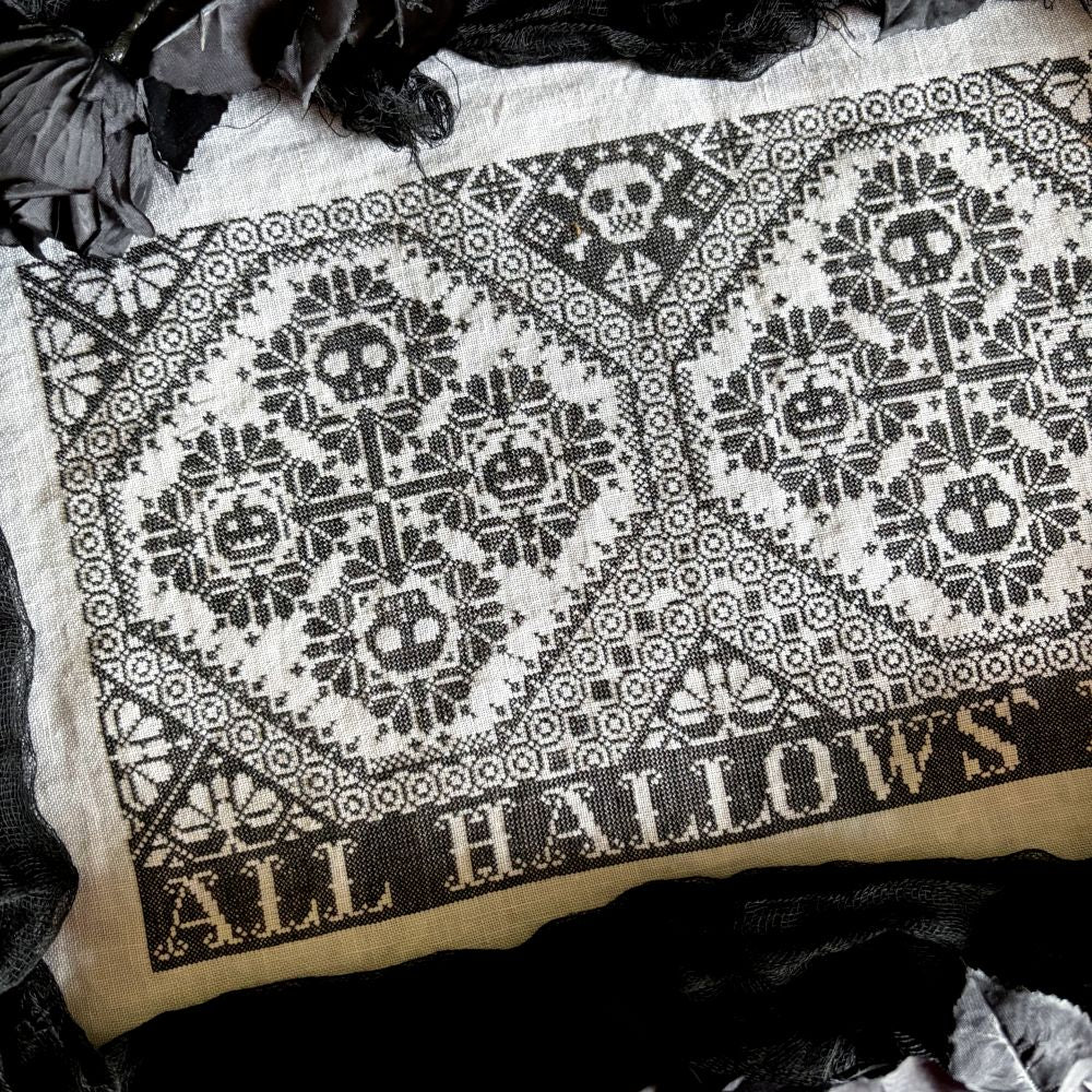 Embroidery pattern with skull design and 'All Hallows' text on fabric