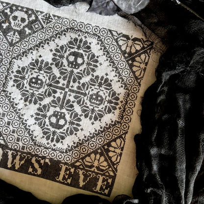 Patterned fabric with skull designs and 'Halloween Eve' text on a dark background
