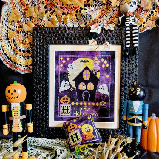 Halloween-themed cross-stitch pattern with decorative items on a black background