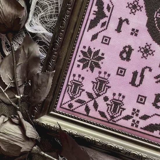 Raven cross-stitch pattern featuring black bird and decorative foliage